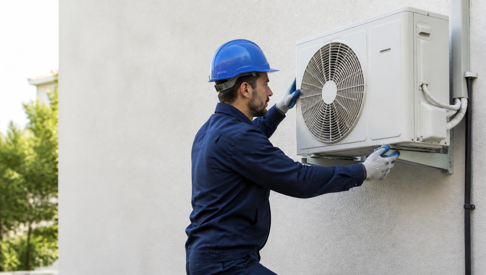 Técnico da JA Climatização instalando ar-condicionado